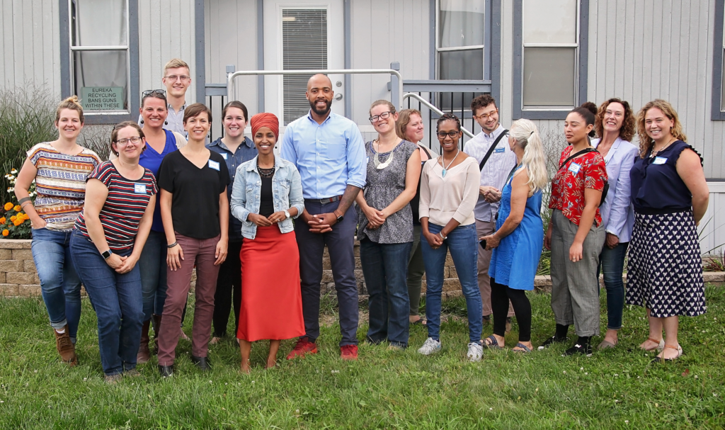 Representative Ilhan Omar and other visitors pose with the Eureka team.